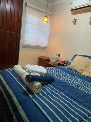 a bedroom with two beds with blue sheets and a window at hermosa habitacion in Barranquilla