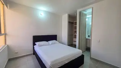 a small bedroom with a white bed and a mirror at Capriella, Serena Del Mar in Cartagena de Indias