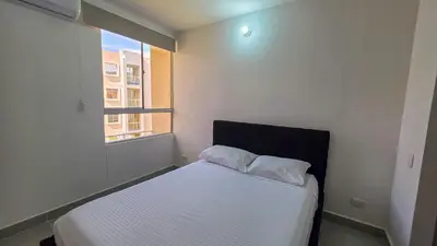 a small bedroom with a bed with a window at Capriella, Serena Del Mar in Cartagena de Indias