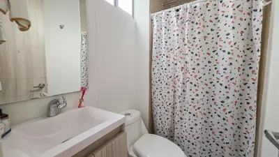 a bathroom with a toilet and a shower curtain at Capriella, Serena Del Mar in Cartagena de Indias
