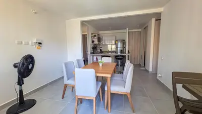 a dining room with a wooden table and chairs at Capriella, Serena Del Mar in Cartagena de Indias