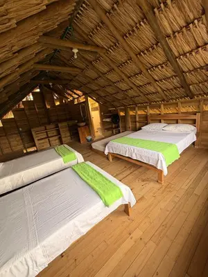 two beds in a room with a wooden ceiling at Cabaña de playa 6 personas con cocina y kiosko privado in Moñitos
