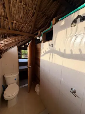 a bathroom with a toilet in a house at Cabaña de playa 6 personas con cocina y kiosko privado in Moñitos