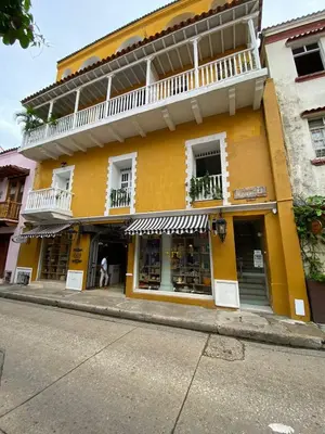 a yellow building on the side of a street at Experience the magic of the Calle de las Damas historic center in Cartagena de Indias