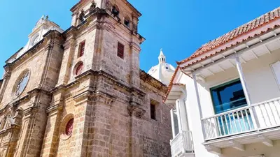 an old brick building with a clock tower on it at Experience the magic of the Calle de las Damas historic center in Cartagena de Indias