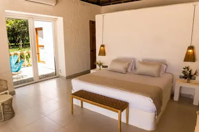 a bedroom with a bed with a bench in it at Paradise Private Kaimari Ocean Villa in Cartagena de Indias
