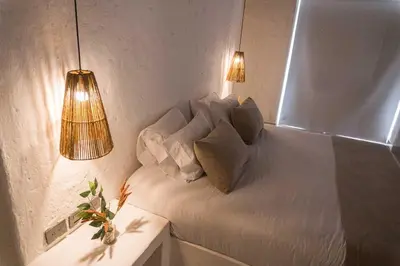 a room with a white bed with two pillows at Paradise Private Kaimari Ocean Villa in Cartagena de Indias