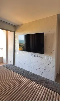 a bedroom with a flat screen tv on a wall at Aqua Marine Suite - Santa Marina Condo in Santa Marta