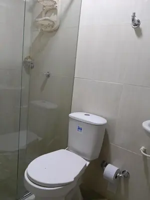 a bathroom with a toilet and a glass shower at Apartamento cerca a la playa y al aeropuerto in Santa Marta