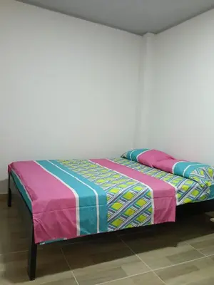a bed with a colorful blanket on top of it at Apartamento cerca a la playa y al aeropuerto in Santa Marta