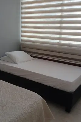 a bed sitting next to a window in a bedroom at Beatifull apartment near Hilton hotel in Cartagena de Indias