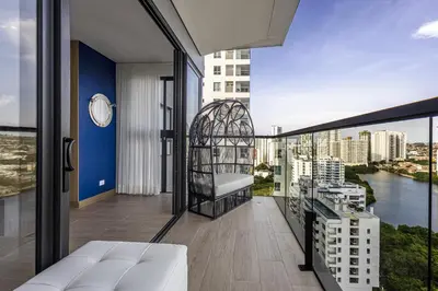 a balcony with a white couch and a clock on a building at NEW Apartment, best rooftop pool view, Cartagena - Visitors NOT ALLOWED in Cartagena de Indias
