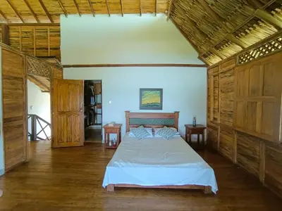 a bedroom with a bed in a room with wooden walls at Sarao Mar in Moñitos