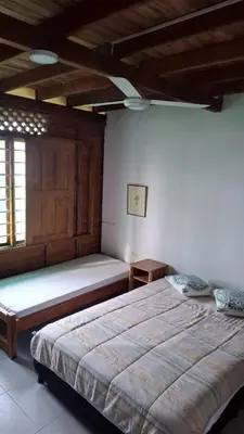 a bedroom with a large bed and a wooden ceiling at Sarao Mar in Moñitos