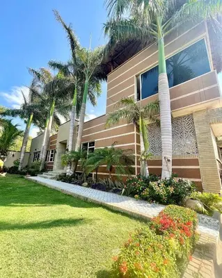a house with palm trees in front of it at Hermosa Villa de Lujo, De Kabaña in Santa Veronica