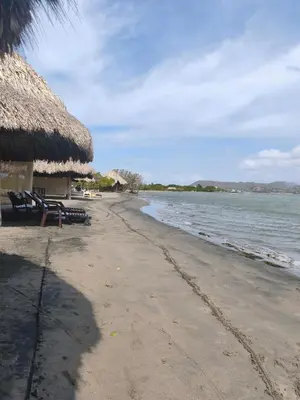 an empty beach with chairs and a thatched building at Apto puerto velero in Barranquilla