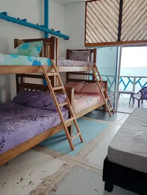 a room with three bunk beds and a balcony at Paraíso de corales in Playa Blanca