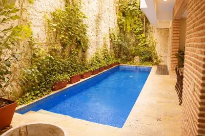 an indoor pool with plants on a wall at Casa Del Hobo in Cartagena de Indias