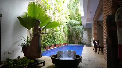 a statue of a woman standing next to a swimming pool at Casa Del Hobo in Cartagena de Indias