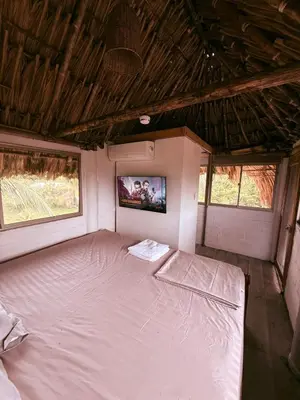 a bedroom with a bed with a tv on the wall at Cabaña de Lujo en Isla Fuerte VIP in Isla Fuerte