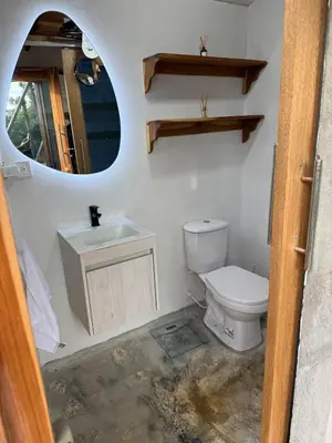 a bathroom with a toilet and a sink and a mirror at Cabaña de Lujo en Isla Fuerte VIP in Isla Fuerte