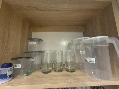 a row of glasses sitting on a wooden shelf at Precioso apartamento cerca del mar in Cartagena de Indias