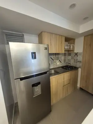 a stainless steel refrigerator in a kitchen with wooden cabinets at Precioso apartamento cerca del mar in Cartagena de Indias