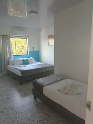two beds in a room with a window at Hotel Montecarlo by Croma in Santiago