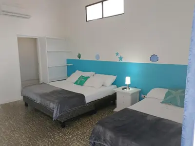 a bedroom with two beds and a blue wall at Hotel Montecarlo by Croma in Santiago