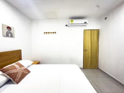 a bedroom with a white bed and a wooden door at Coral del Mar 1 in Tolú