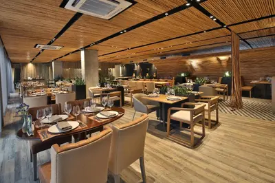 a restaurant with wooden ceilings and tables and chairs at Movich Buró 51 in Barranquilla
