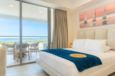 a bedroom with a bed and a view of the ocean at Luxury Apartment Suite Lake View 2 min Airport in Cartagena de Indias