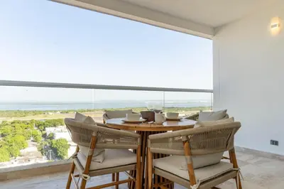 a dining room with a table and chairs and a large window at Luxury Apartment Suite Lake View 2 min Airport in Cartagena de Indias