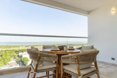 a dining room with a table and chairs and a large window at Luxury Apartment Suite Lake View 2 min Airport in Cartagena de Indias