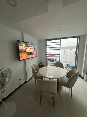 a dining room with a table and chairs and a tv at Sebastián torres in Barranquilla