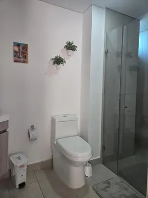 a bathroom with a toilet and a glass shower at Brand New Perfectly Located 2bedroom in CieloMar in Cartagena de Indias
