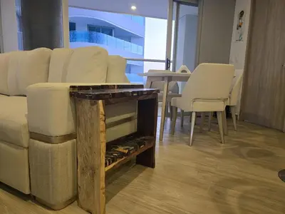 a living room with a couch and a table with chairs at Brand New Perfectly Located 2bedroom in CieloMar in Cartagena de Indias