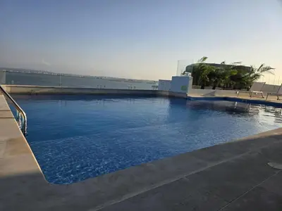 a large swimming pool with blue water on a building at Brand New Perfectly Located 2bedroom in CieloMar in Cartagena de Indias