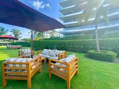 a group of chairs and a table with an umbrella at Morros Zoe - Ocean View Paradise, Serena Del Mar, Cartagena in Cartagena de Indias