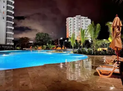 a large swimming pool at night with buildings at Apartamento frente al mar- edificio santa marina in Santa Marta