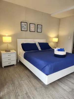 a bedroom with a large bed with blue sheets and two lamps at Tu refugio en la playa, moderno cómodo con estilo in Cartagena de Indias