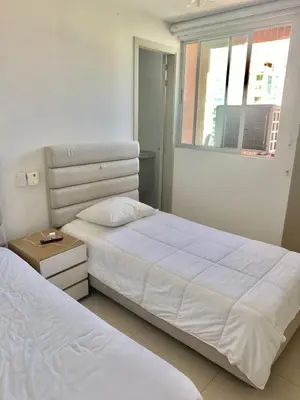 a bedroom with two white beds and a window at Apartamento en Riomar a pocas cuadras CC Buenavista in Barranquilla