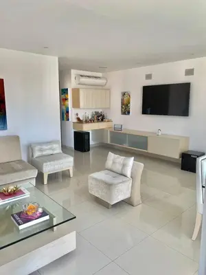 a living room with a couch and a tv on the wall at Apartamento en Riomar a pocas cuadras CC Buenavista in Barranquilla