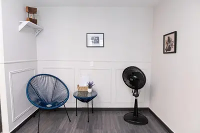 a room with a fan and a blue chair at Comodo apartamento en el norte de Barranquilla in Barranquilla