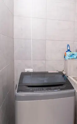 a washing machine in a bathroom with a tiled wall at Comodo apartamento en el norte de Barranquilla in Barranquilla