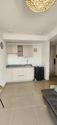 a living room with a kitchen and a couch at Apto Doral Suite Zona exclusiva Cartagena in Cartagena de Indias