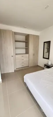 a bedroom with a white bed and wooden cabinets at Apto Doral Suite Zona exclusiva Cartagena in Cartagena de Indias