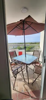 a table and chairs with an umbrella on a balcony at Apto Doral Suite Zona exclusiva Cartagena in Cartagena de Indias