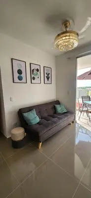a living room with a brown couch and a chandelier at Apto Doral Suite Zona exclusiva Cartagena in Cartagena de Indias