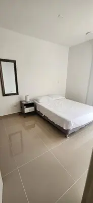 a white room with a bed and a mirror at Apto Doral Suite Zona exclusiva Cartagena in Cartagena de Indias